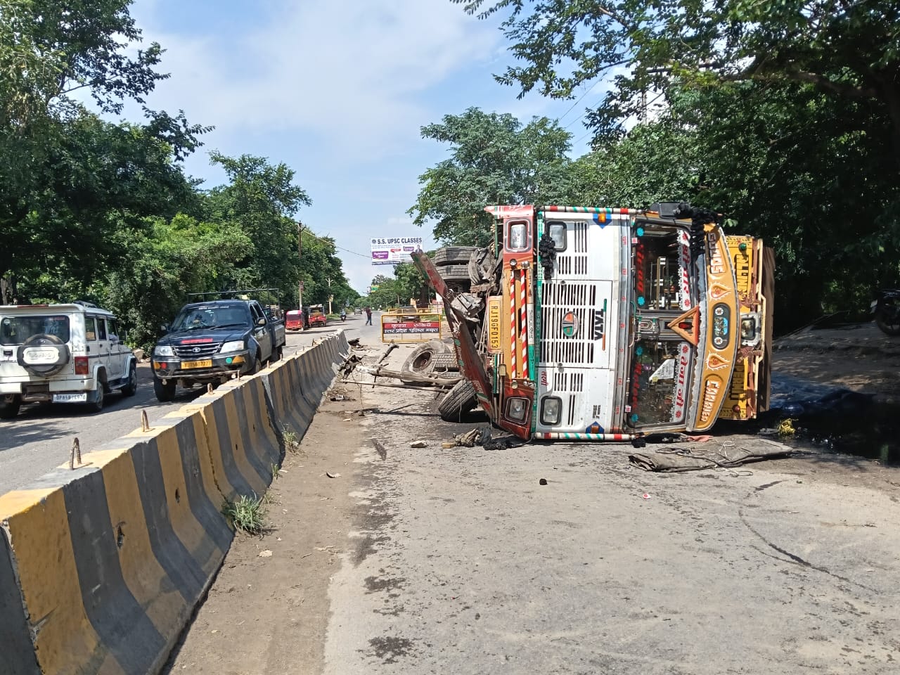 डिवाइडर से टकराकर पलटा ट्रक मुश्किल से बची ड्राइवर की जान